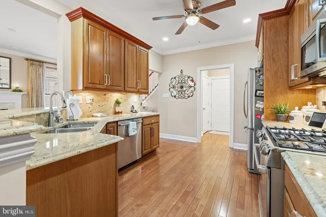 a kitchen with stainless steel appliances granite countertop a refrigerator stove and sink