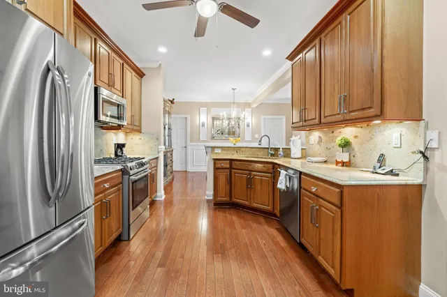 a kitchen with stainless steel appliances granite countertop a sink stove and cabinets