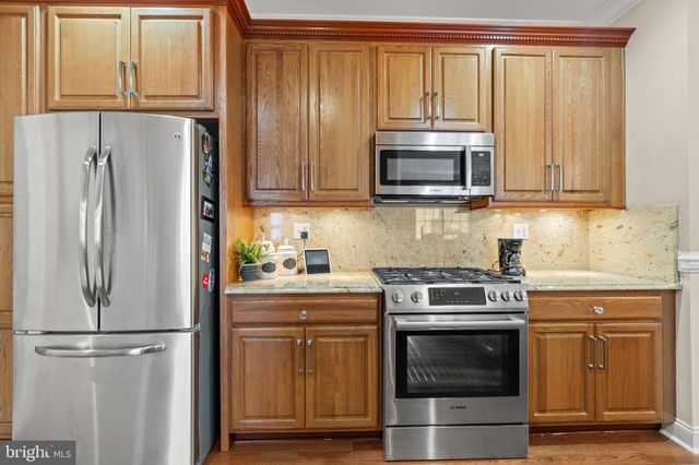 a kitchen with stainless steel appliances granite countertop a refrigerator and a stove