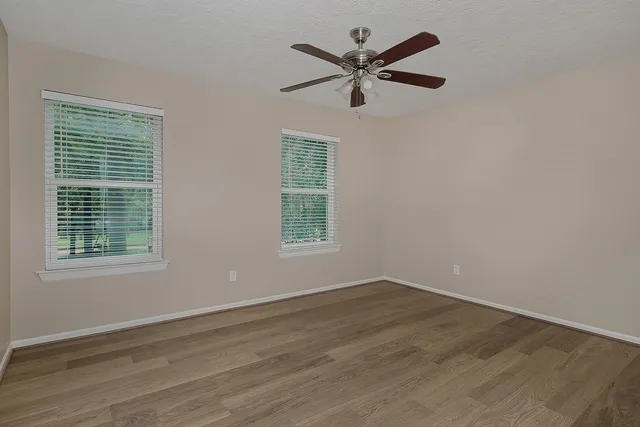a view of a big room with wooden floor and windows