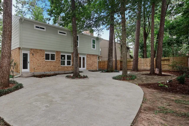 a view of a house with backyard and trees
