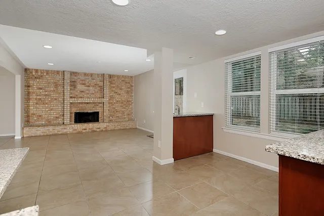 a view of an empty room with a fireplace and a window