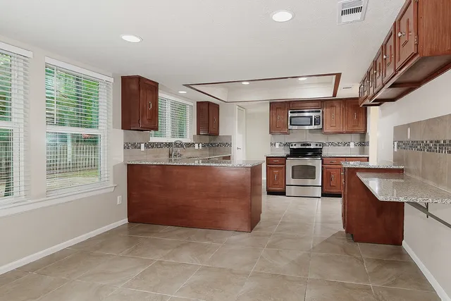a kitchen with stainless steel appliances granite countertop a stove top oven a sink a counter top space and cabinets