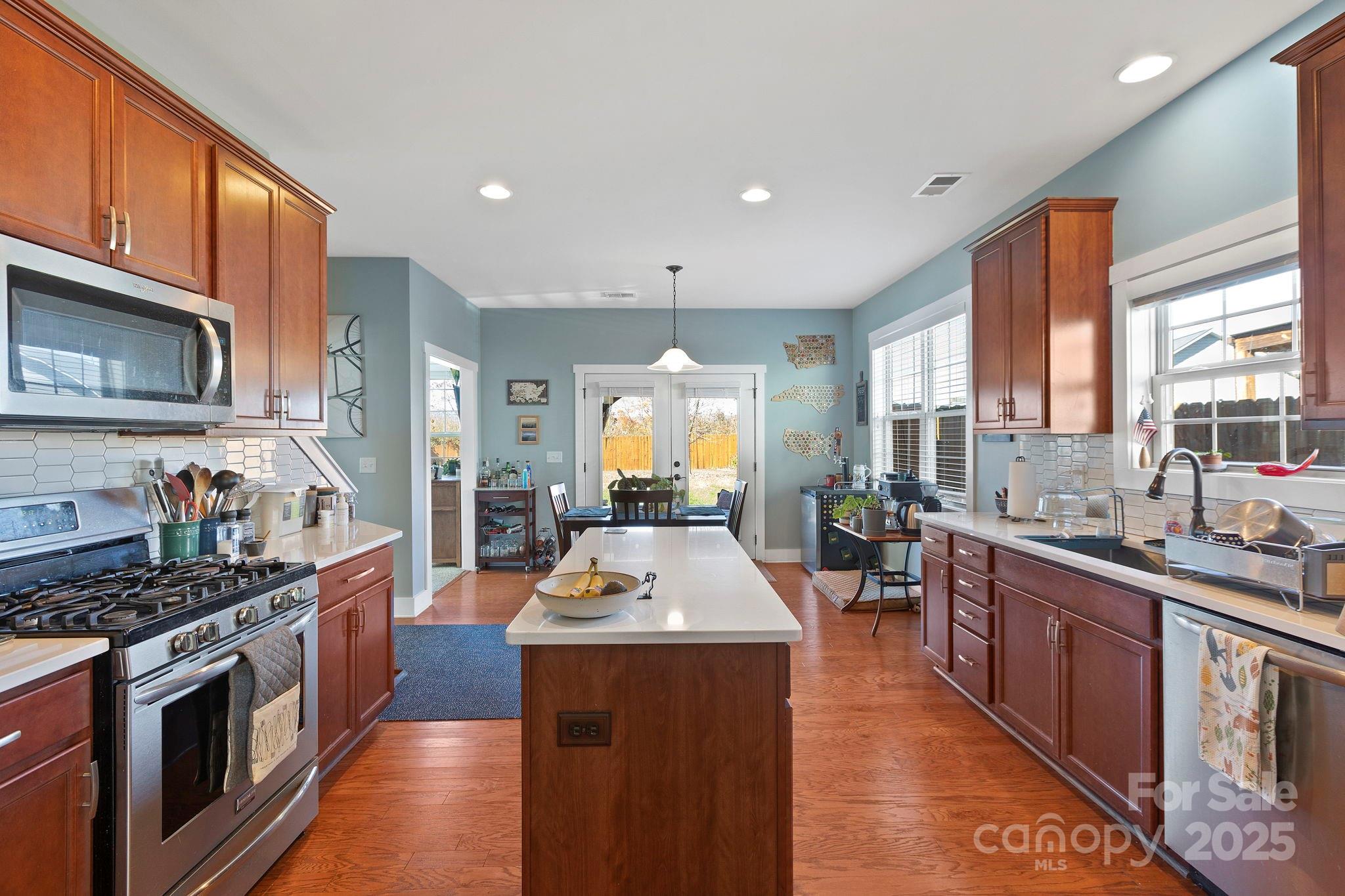 28 South River Road Fletcher, NC 28732 - Photo 14 of 47 a kitchen with stainless steel appliances granite countertop a stove top oven a sink dishwasher a dining table and chairs with wooden floor
