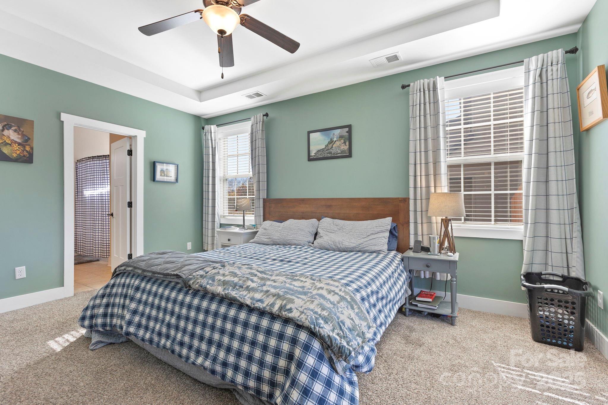 28 South River Road Fletcher, NC 28732 - Photo 21 of 47 a bedroom with a bed and a chandelier