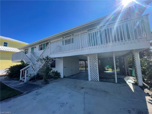 a backyard of a house with barbeque oven table and chairs