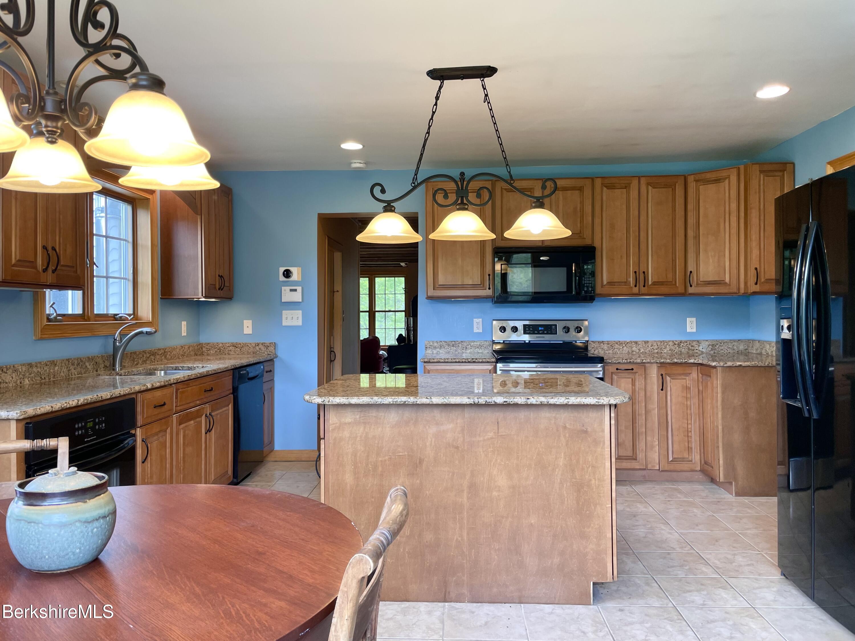 104 North Chester Road Chester, MA 01011 - Photo 12 of 54 a kitchen with stainless steel appliances granite countertop a stove a sink a refrigerator and a wooden cabinets