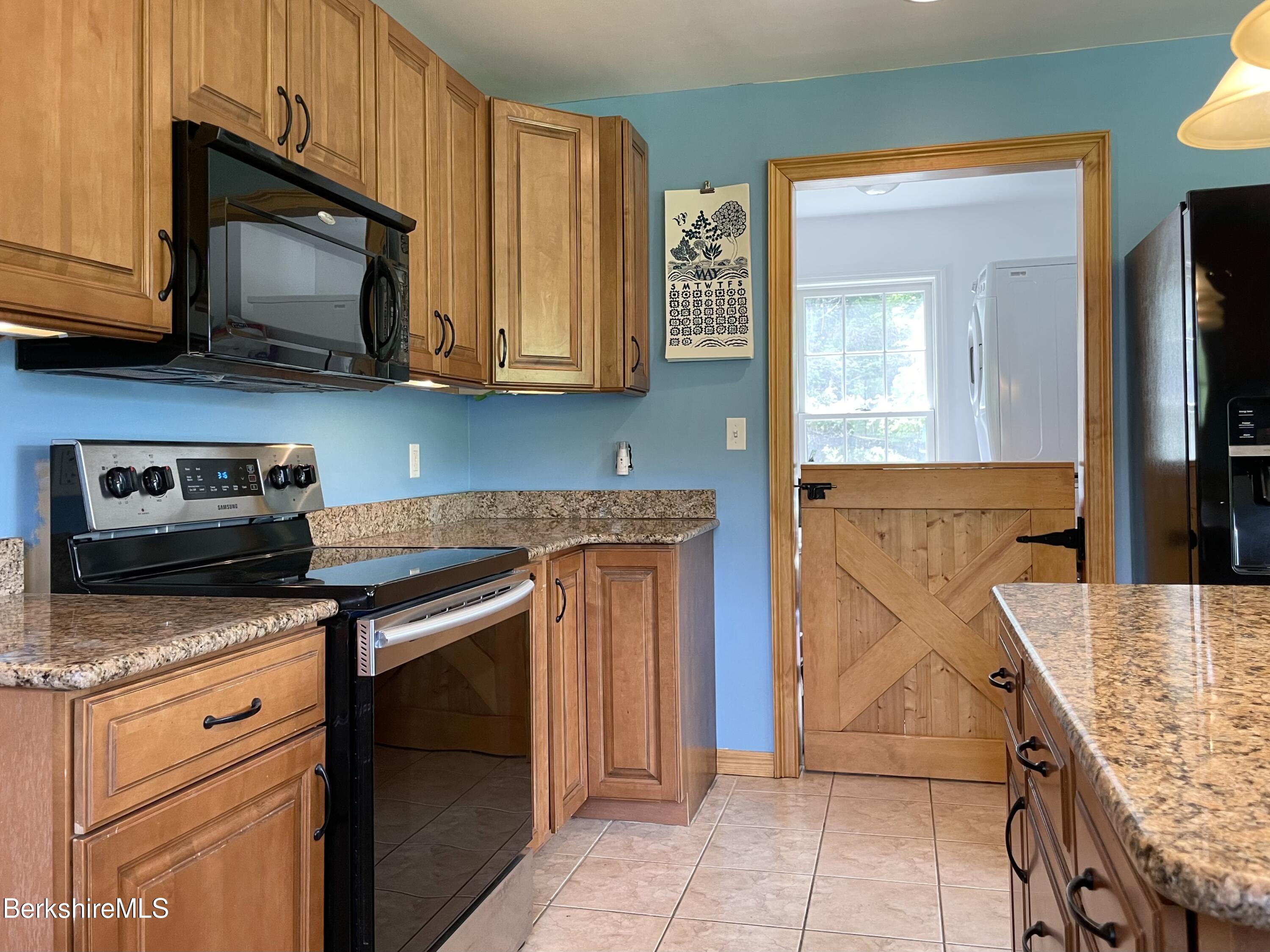104 North Chester Road Chester, MA 01011 - Photo 13 of 54 a kitchen with stainless steel appliances granite countertop a stove microwave and cabinets