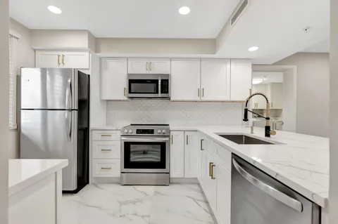 a kitchen with a sink appliances and cabinets