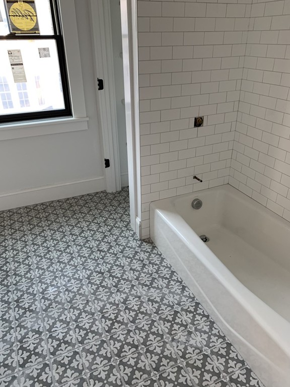10 Lincoln Street, Unit 1 Natick, MA 01760 - Photo 4 of 5 a bathroom with a bathtub and a shower