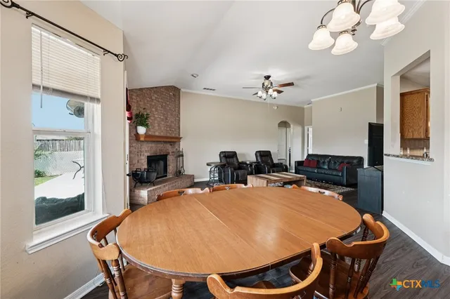 a dining room with wooden floor and stainless steel appliances