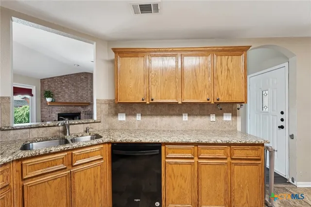 a kitchen with granite countertop stainless steel appliances a sink stove and cabinets