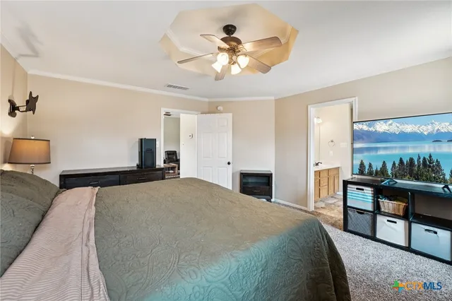 a spacious bedroom with a large bed and a chandelier