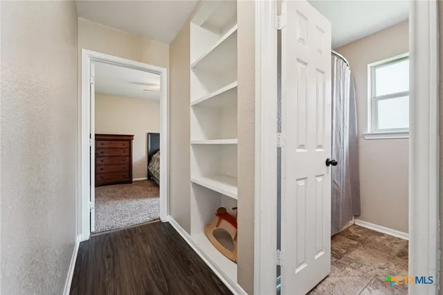 a view of a hallway to closet and wooden floor