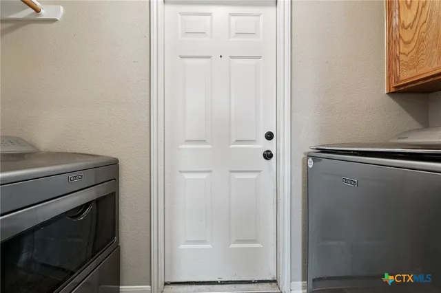 a view of a backyard with table and chairs potted plants and wooden fence