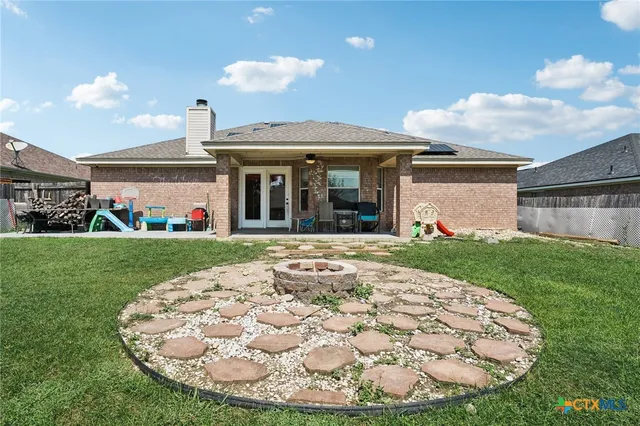 a view of a house with a big yard and large tree
