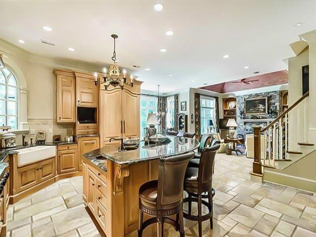 6036 Over Hadden Court Raleigh, NC 27614 - Photo 12 of 30 Spacious kitchen with abundance of top quality cabinets, one-of-a-kind granite countertops, oversized island with room for 6+ barstools to enjoy with friends/family, farm sink, high end appliances and tile flooring. Kitchen-Hearth-Breakfast Room