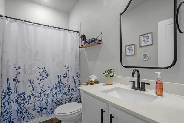 a bathroom with a sink vanity mirror and toilet