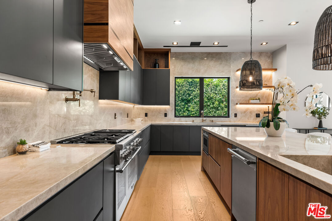 13463 Chandler Boulevard Sherman Oaks, CA 91401 - Photo 11 of 38 a kitchen with stainless steel appliances granite countertop a sink a stove and a wooden floors
