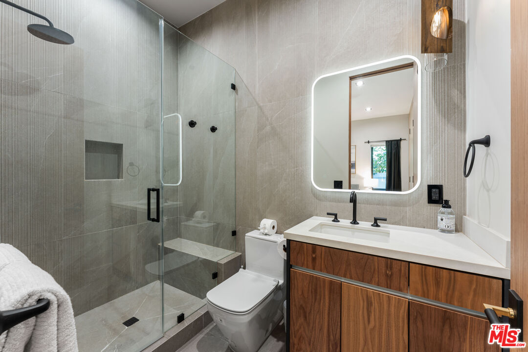 13463 Chandler Boulevard Sherman Oaks, CA 91401 - Photo 16 of 38 a bathroom with a double vanity sink toilet and shower