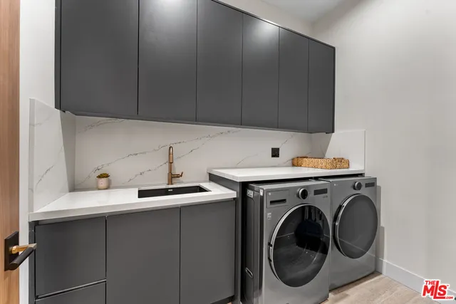 a utility room with sink dryer and washer