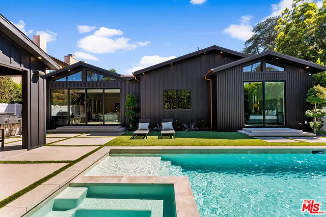 a view of swimming pool with lawn chairs and plants