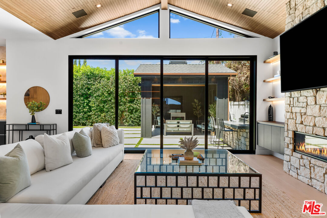 13463 Chandler Boulevard Sherman Oaks, CA 91401 - Photo 6 of 38 a living room with furniture a flat screen tv and a floor to ceiling window