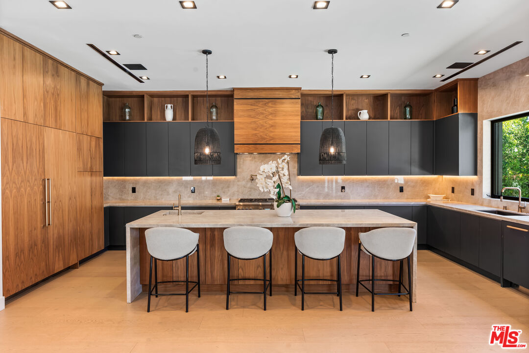 13463 Chandler Boulevard Sherman Oaks, CA 91401 - Photo 9 of 38 a kitchen with a sink chairs and dining table