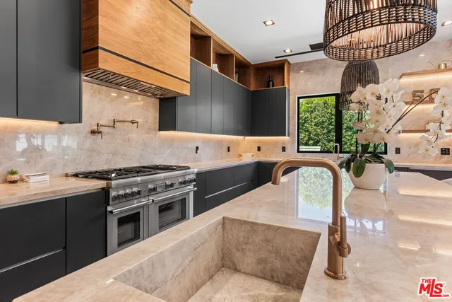 a kitchen with stainless steel appliances granite countertop a stove a sink and a refrigerator