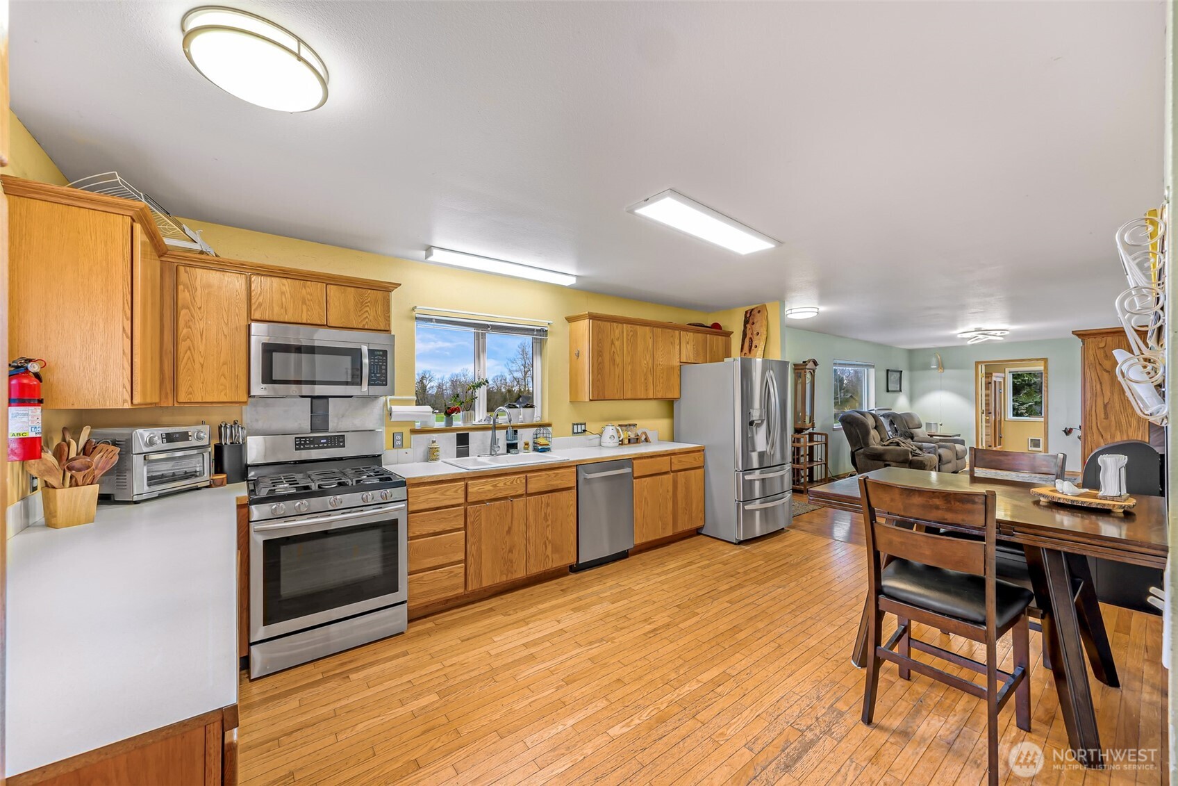 4610 Curtis Road Bellingham, WA 98226 - Photo 5 of 34 a kitchen with stainless steel appliances kitchen island granite countertop a stove top oven a sink dishwasher and white cabinets with wooden floor