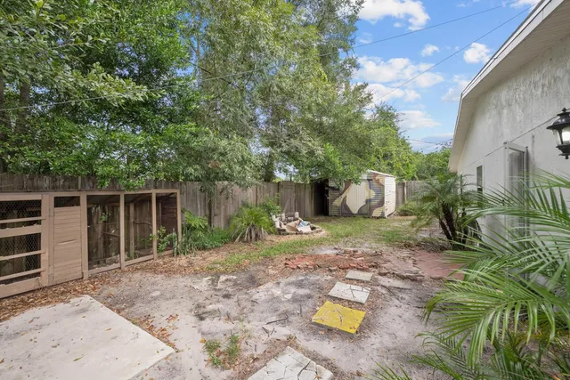 a view of a small house with wooden fence