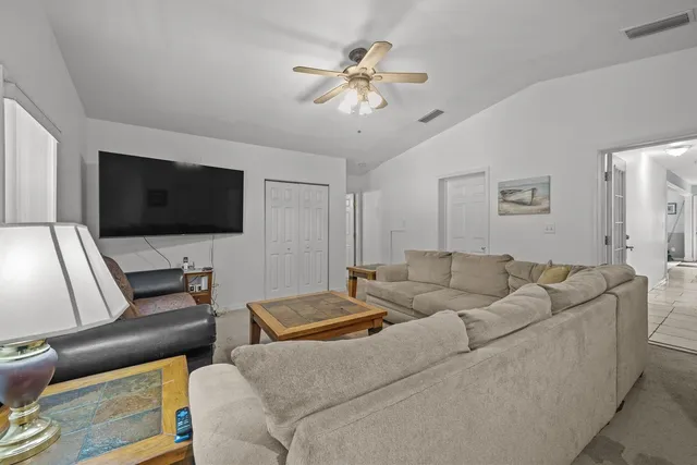 a living room with furniture a flat screen tv and a window