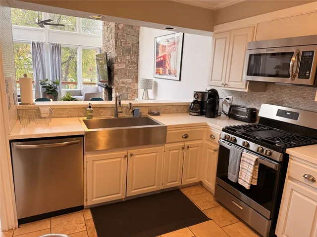 a kitchen with stainless steel appliances granite countertop a sink stove and microwave