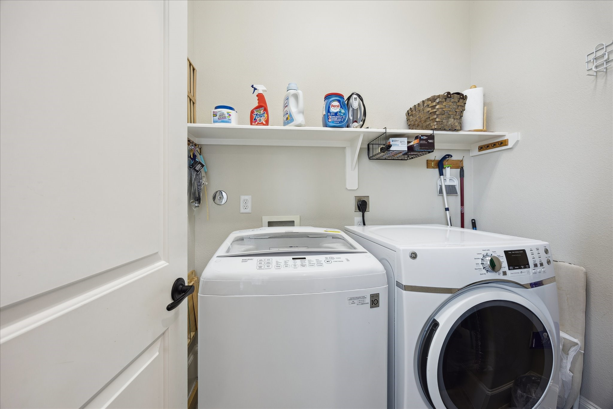 1110 West 25th Street Houston, TX 77008 - Photo 17 of 40 This thoughtfully designed utility room adds everyday convenience with smart, functional style. Featuring a full-size washer and dryer, built-in shelving, and ample storage for supplies, the space is organized and efficient. Everything has its place, making laundry and household tasks feel simple and streamlined.