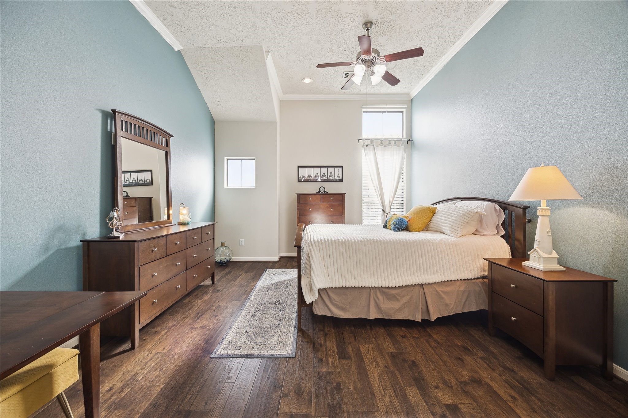 1110 West 25th Street Houston, TX 77008 - Photo 20 of 40 This serene primary bedroom is a true retreat, offering space, comfort, and a calming sense of privacy. Soaring ceilings, soft natural light, and a soothing color palette create an airy, tranquil atmosphere, while warm hardwood floors add richness and warmth. The room easily accommodates a full bedroom suite and additional seating or workspace, making it both luxurious and functional.