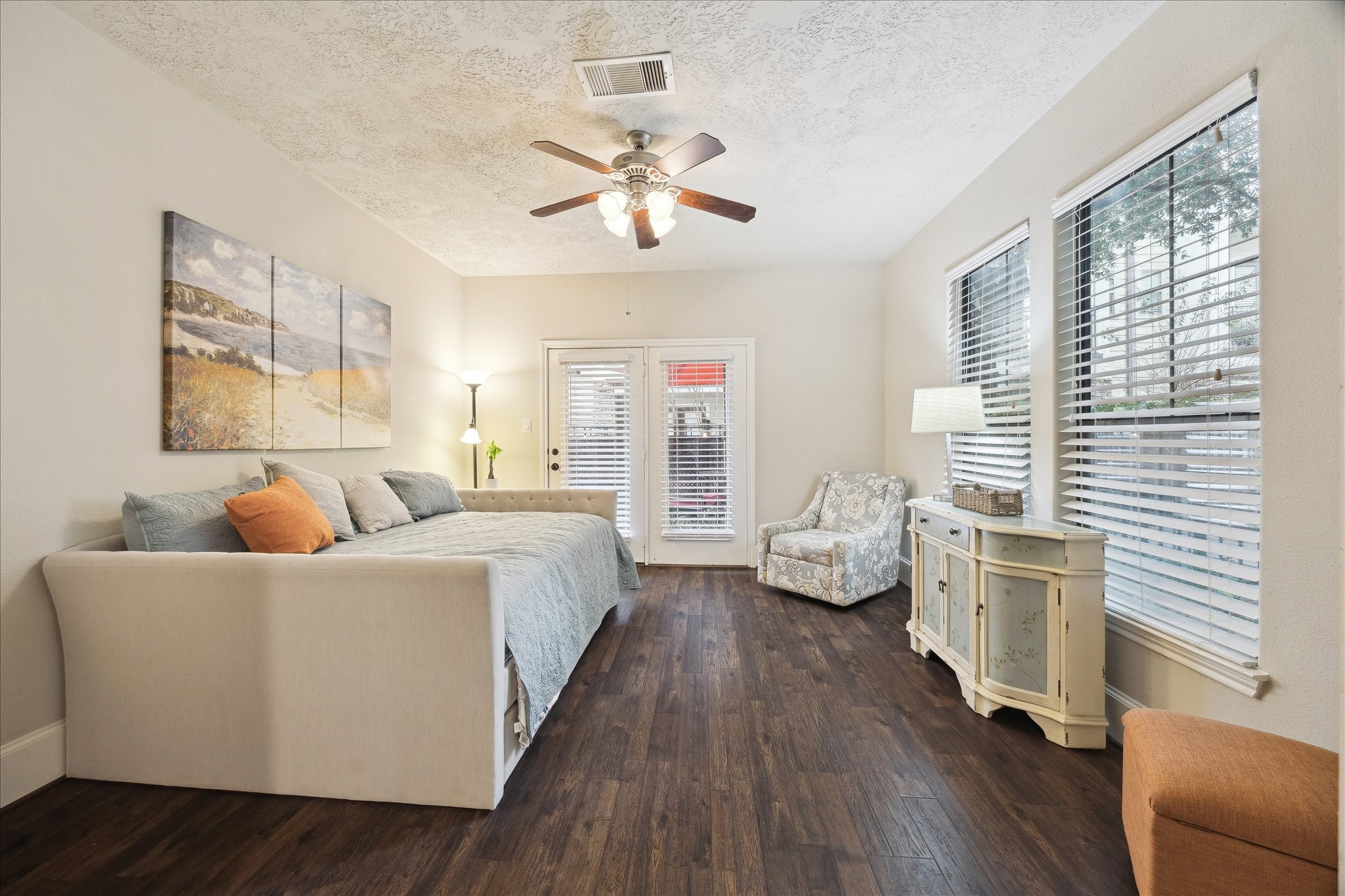 1110 West 25th Street Houston, TX 77008 - Photo 4 of 40 This inviting downstairs bedroom offers the perfect blend of comfort, light, and flexibility—ideal for guests, a home office, or a private retreat. Wide-plank wood floors ground the space with warmth, while oversized windows and French doors flood the room with natural light and create an easy connection to the outdoors. Soft neutral tones, custom blinds, and thoughtful finishes give the room a calm, polished feel that’s instantly welcoming.