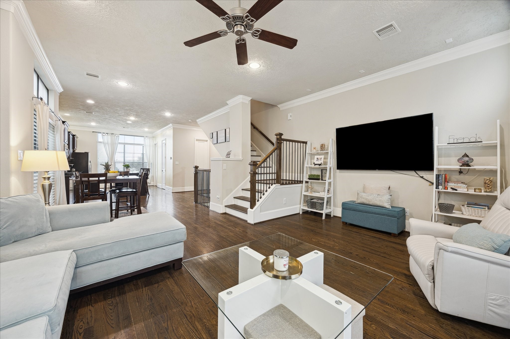 1110 West 25th Street Houston, TX 77008 - Photo 7 of 40 This expansive living room anchors the home with a perfect balance of openness and warmth - the thoughtful layout flows seamlessly into the dining area—ideal for both everyday living and entertaining. The centrally placed staircase adds architectural interest and a sense of scale, and the spacious seating areas offer flexibility for relaxing, hosting, or gathering with friends.