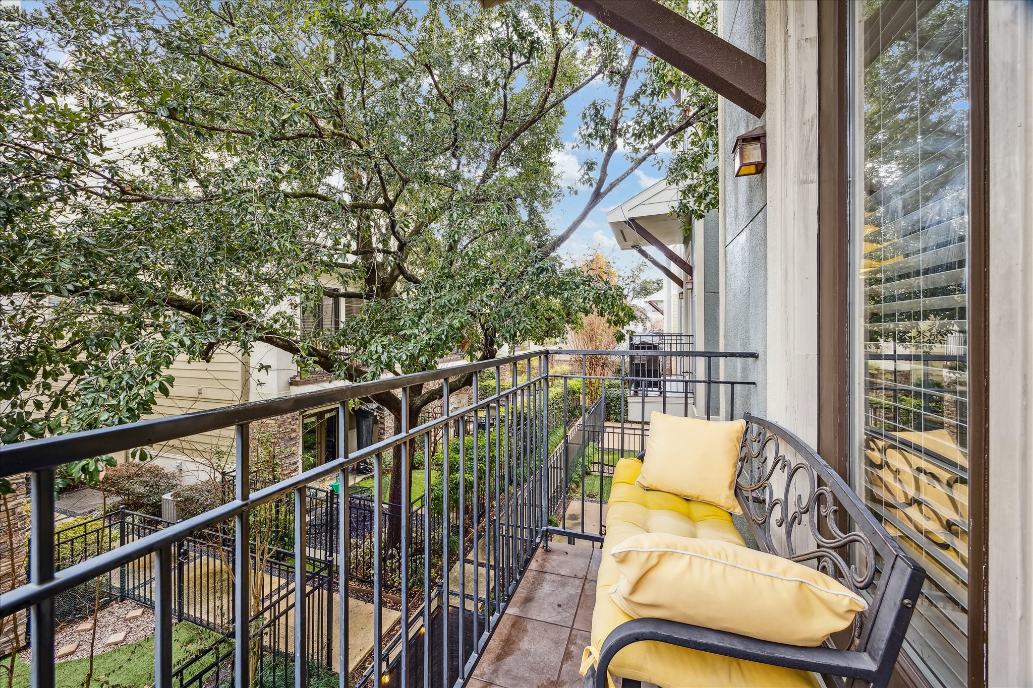 1110 West 25th Street Houston, TX 77008 - Photo 8 of 40 This charming balcony offers a peaceful escape tucked among mature trees, creating a rare sense of privacy and serenity in the heart of the city. Perfectly sized for morning coffee or evening unwinding, it feels like a cozy perch above it all, with leafy views and gentle natural light filtering through the branches.