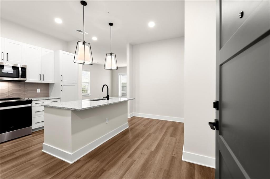 2648 Sandy Plains Road, Unit 301 Marietta, GA 30062 - Photo 1 of 46 a kitchen with kitchen island white cabinets and stainless steel appliances