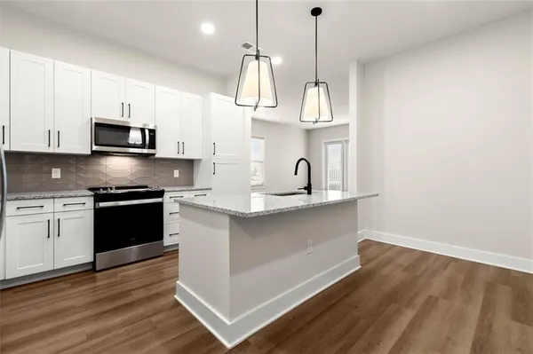 a kitchen with stainless steel appliances a stove a sink and a microwave
