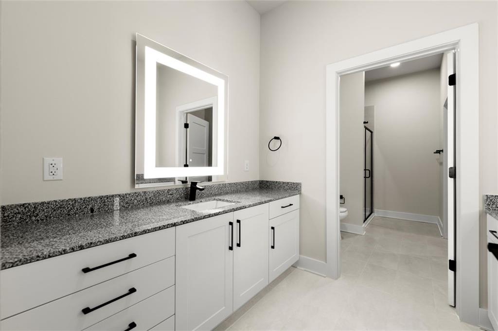 2648 Sandy Plains Road, Unit 301 Marietta, GA 30062 - Photo 24 of 46 a bathroom with a granite countertop sink and a mirror