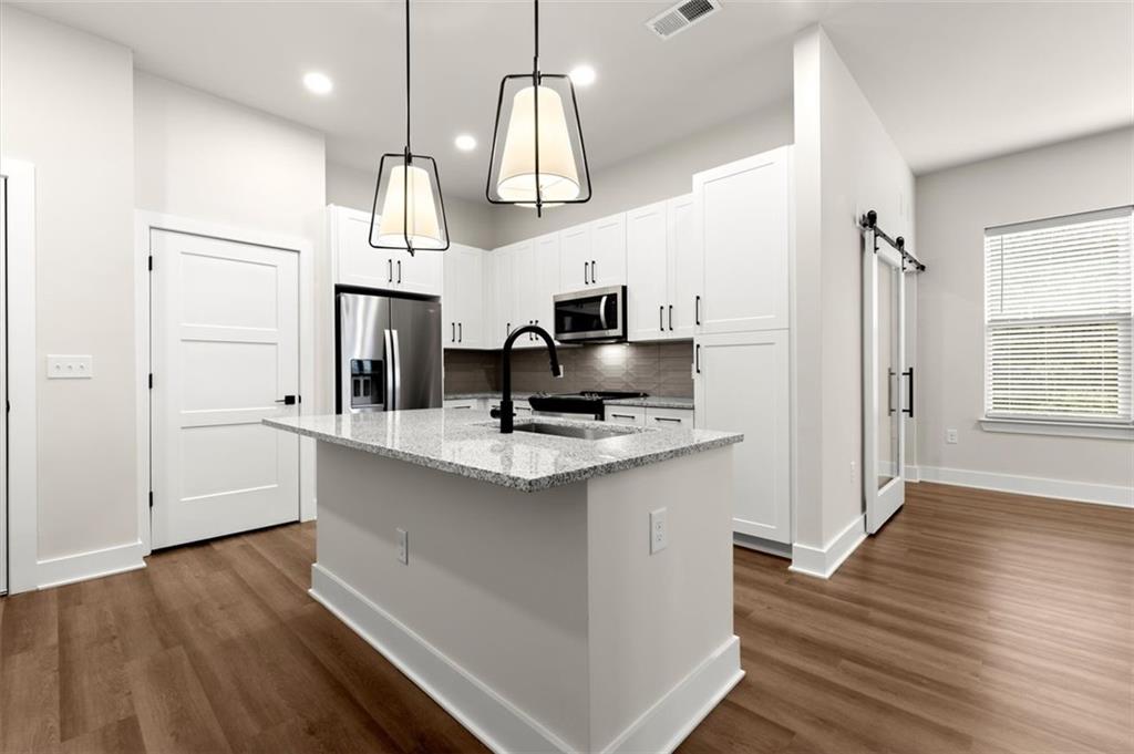 2648 Sandy Plains Road, Unit 301 Marietta, GA 30062 - Photo 3 of 46 a kitchen with stainless steel appliances a sink and wooden floors