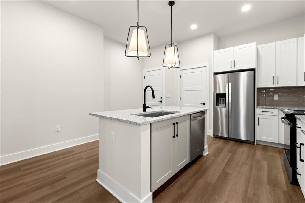 2648 Sandy Plains Road, Unit 301 Marietta, GA 30062 - Photo 5 of 46 a kitchen with stainless steel appliances granite countertop a sink a stove a refrigerator and island with wooden floor