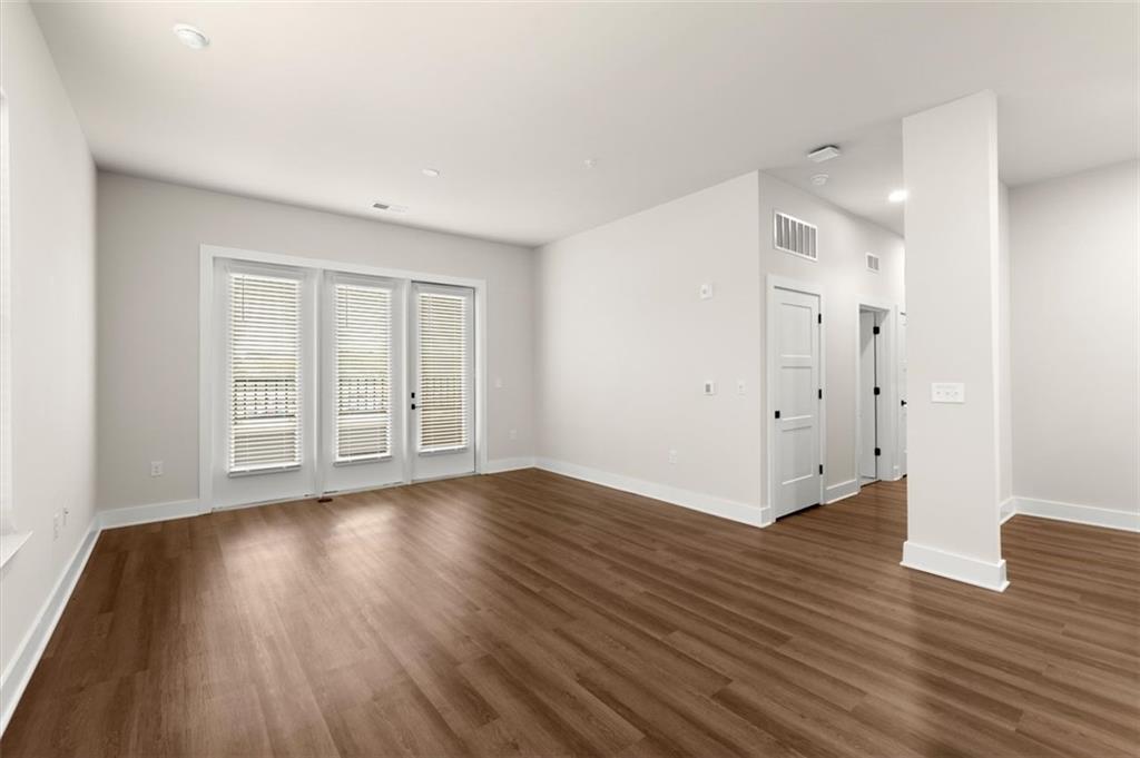 2648 Sandy Plains Road, Unit 301 Marietta, GA 30062 - Photo 10 of 46 a view of an empty room with wooden floor and a window