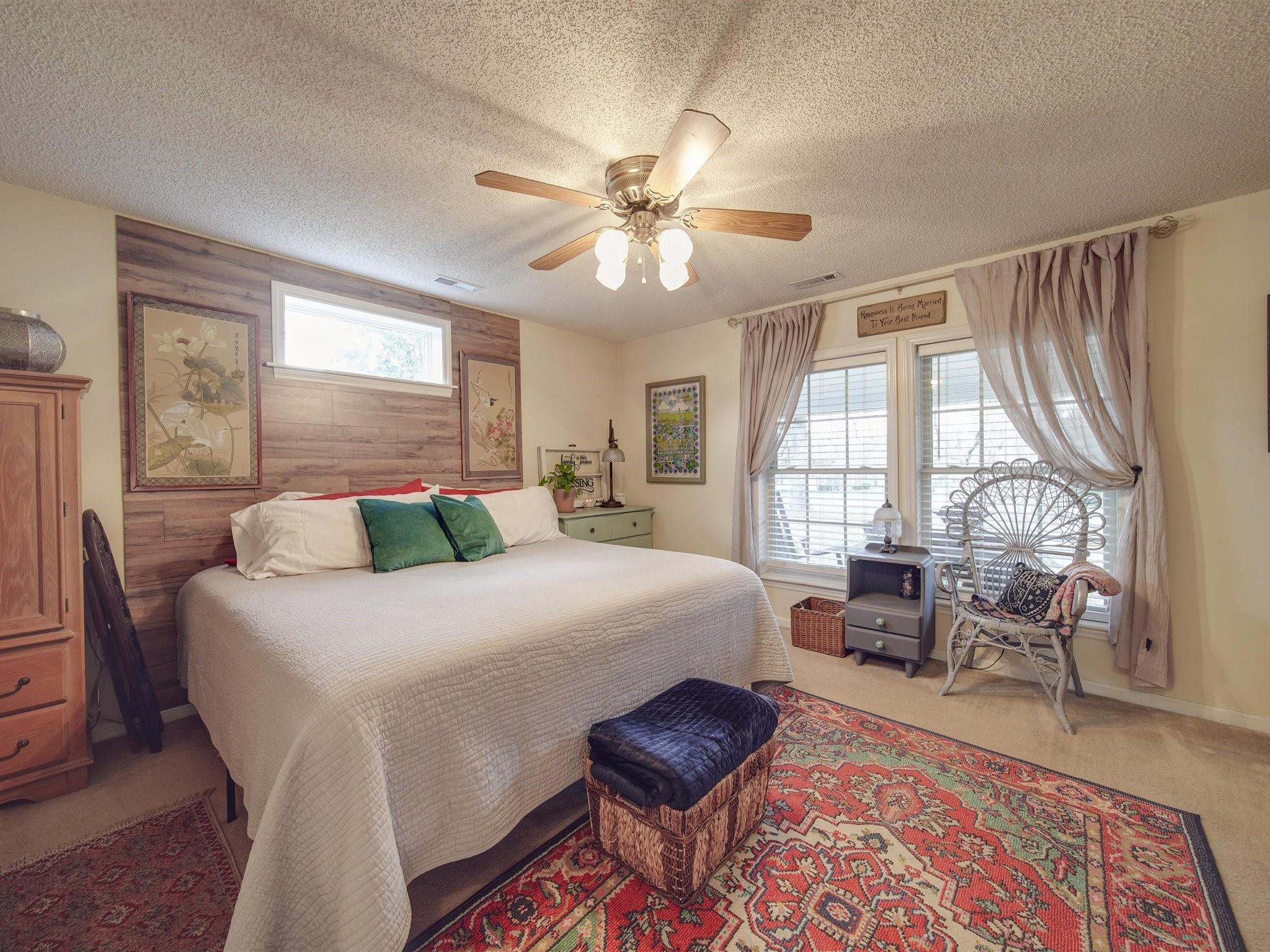 3410 Helms Pond Road Monroe, NC 28110 - Photo 34 of 35 a spacious bedroom with a bed a chandelier and a couch