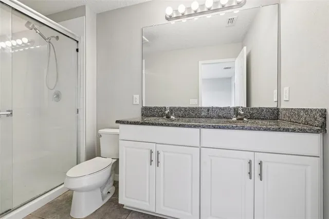 a bathroom with a granite countertop sink toilet and shower