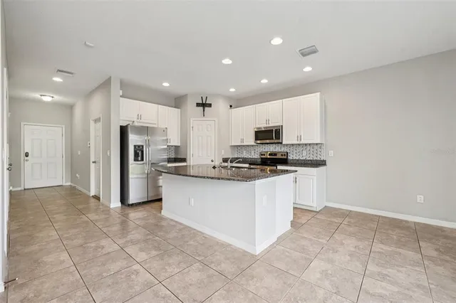 a kitchen with stainless steel appliances granite countertop a refrigerator sink and cabinets