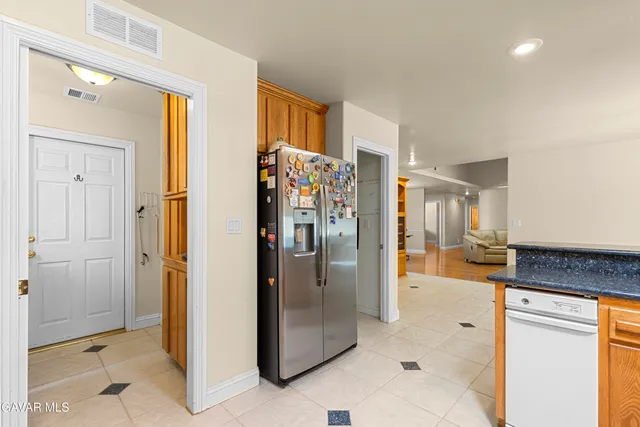 a view of a refrigerator in kitchen and a living room