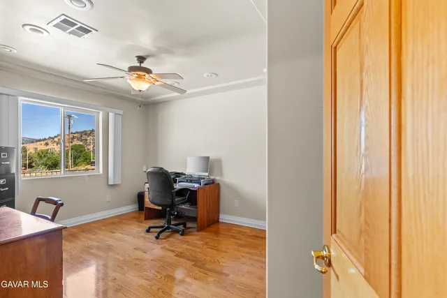 a view of a workspace with furniture and a window
