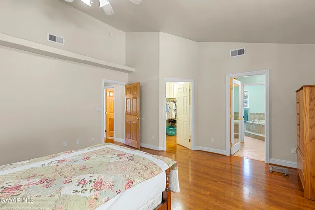 a view of a bedroom with wooden floor and bathroom